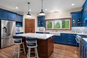 Kitchen with blue cabinets and wood stained island.