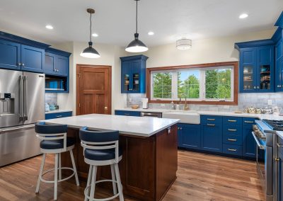 Kitchen with blue cabinets and wood stained island.